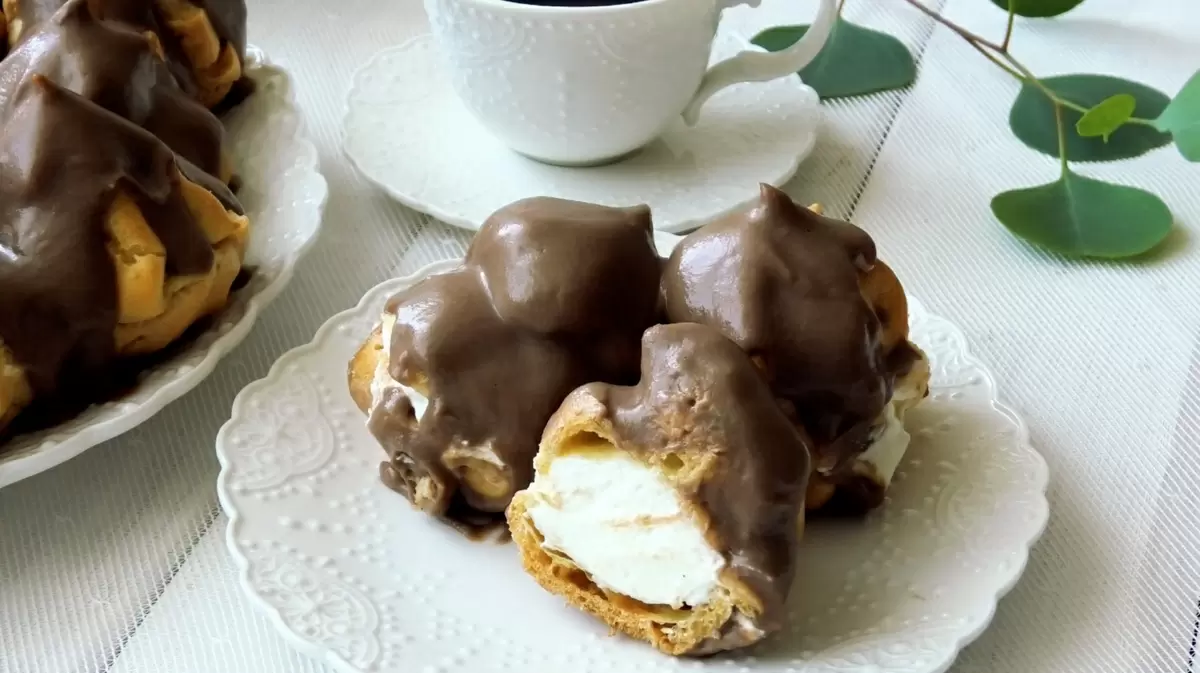 Профитроли с воздушными сливками, покрытые изысканным шоколадным соусом